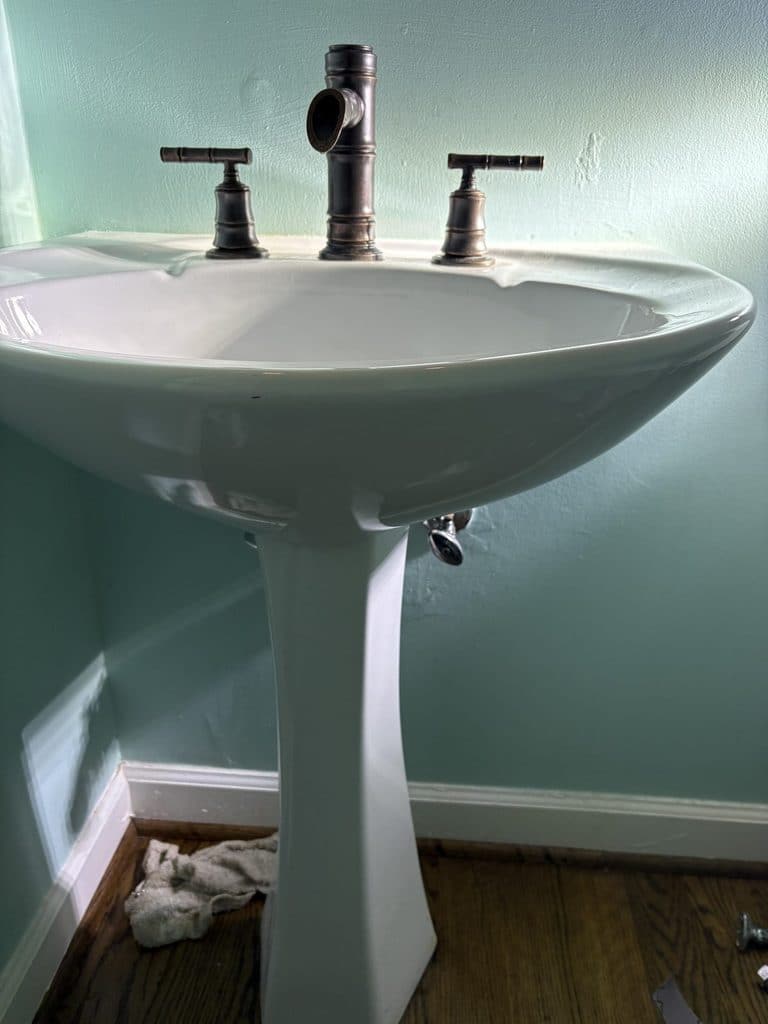 BEFORE — leaking shutoff under the pedestal sink | Leaking shutoff valve under a pedestal sink in Apex, NC