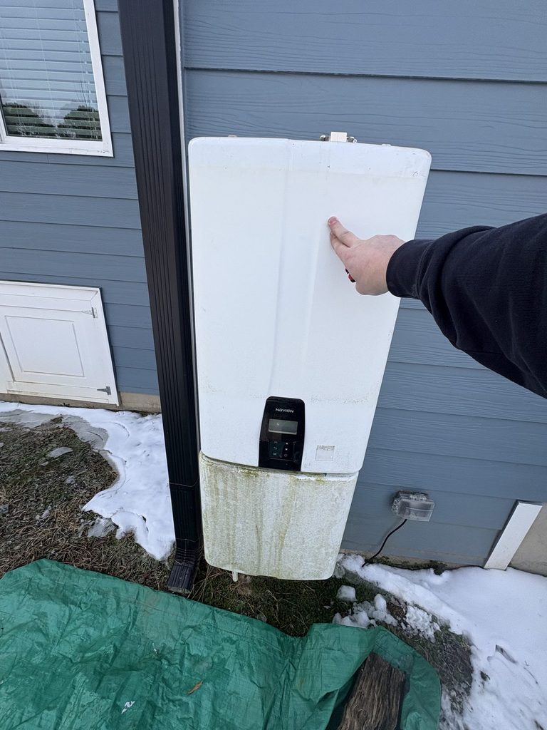 BEFORE — the Navien tankless that quit during the freeze | Navien tankless water heater on the outside wall of an Angier, NC home after a winter freeze |