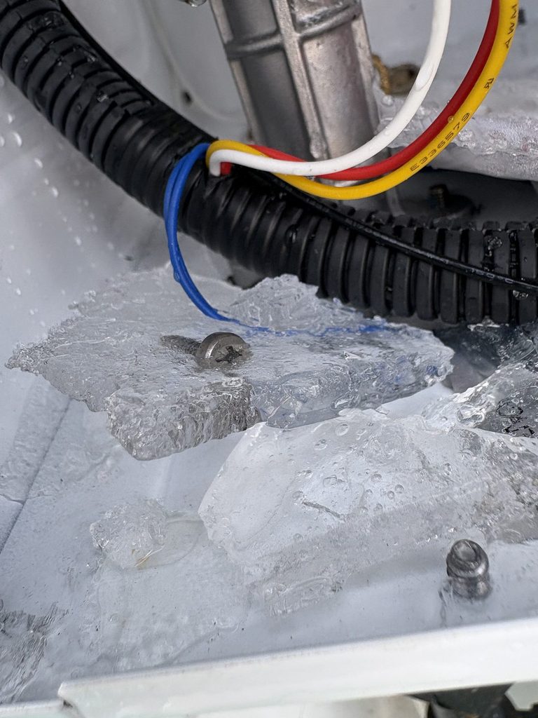 DETAIL — ice inside the cabinet; the heat exchanger had burst | Ice inside a Navien tankless water heater cabinet after the heat exchanger burst in a freeze |