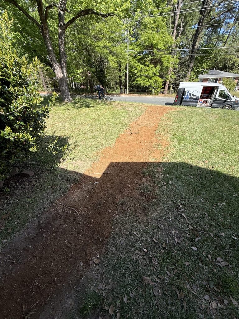 ARC Plumbing van beside a backfilled water line trench at a 1954 home inside the Beltline in Raleigh, NC